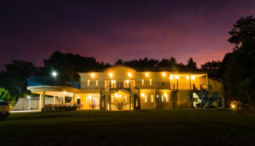 a house lit up at night with lights at Stallage Hotel in São Pedro