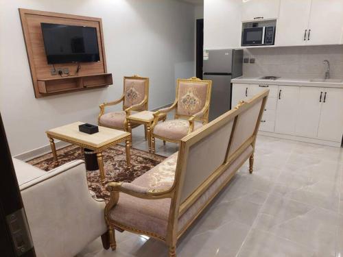 a kitchen with four chairs and a table and a tv at غرفة وصالة فاخرة حي السلامة in Jeddah