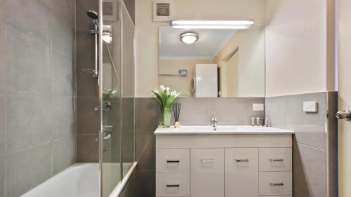 a bathroom with a sink and a shower and a tub at Lawlers 30 in Mount Hotham