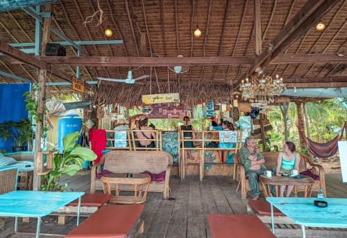grupa ludzi siedzących w restauracji ze stołami w obiekcie Yellow Sun Kampot w mieście Kâmpôt