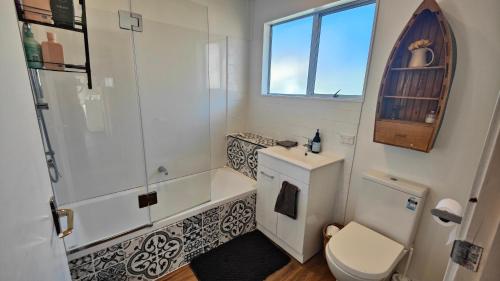 een badkamer met een bad, een toilet en een wastafel bij Spectacular Moana Views in Riverton