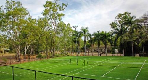 a tennis court with trees in the background at Island Serenity on Magnetic Island in Nelly Bay