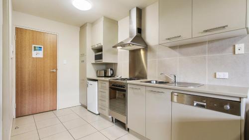 a kitchen with a sink and a stove top oven at Chalet Hotham 7 in Mount Hotham