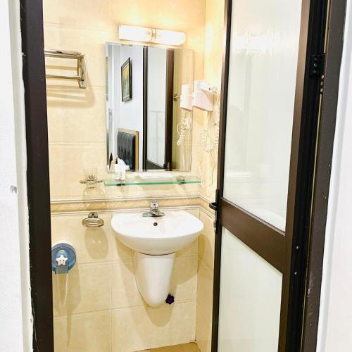 Hoàng Gia Hotel في هانوي: حمام مع حوض ومرآة