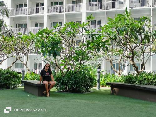 a woman sitting on a bench in front of a building at 1 bedroom unit condo in Manila