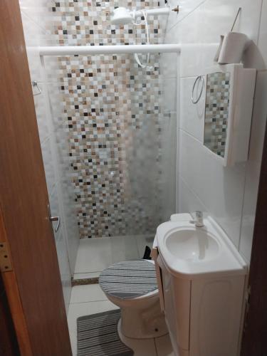 a bathroom with a shower and a toilet and a sink at Parque Jockey Campos in Campos dos Goytacazes