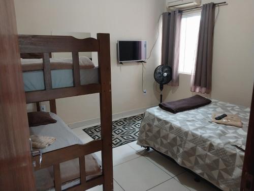 a bedroom with two bunk beds and a television at Parque Jockey Campos in Campos dos Goytacazes