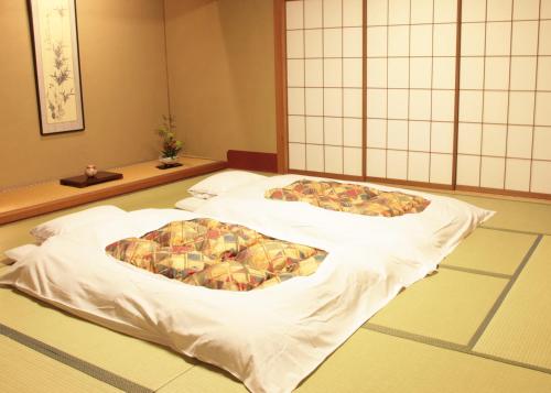 a large bed in a room with aupuncture at Hyoe Koyokaku in Kobe