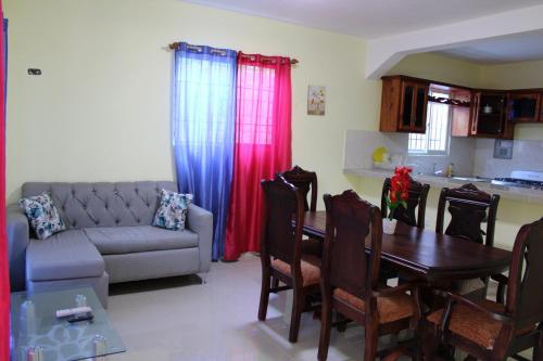 ein Wohnzimmer mit einem Tisch und einem Sofa in der Unterkunft Aparta Hotel Los Deisy in Los Patos