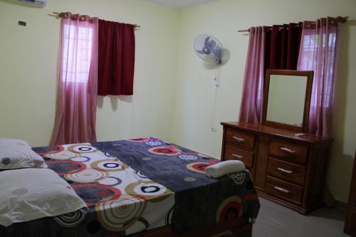 Schlafzimmer mit einem Bett, einer Kommode und einem Spiegel in der Unterkunft Aparta Hotel Los Deisy in Los Patos