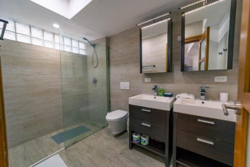 WOW location Kite Beach Oceanfront 2 Bedroom Patio and Pool في كاباريتي: حمام مع دش ومغسلة ومرحاض