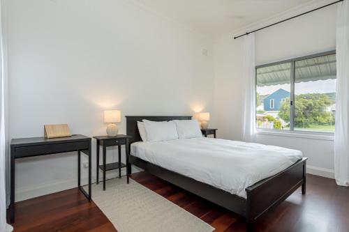 a bedroom with a bed and two tables and a window at Karraleen at Middleton in Albany