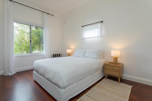 a white bedroom with a bed and a window at Karraleen at Middleton in Albany