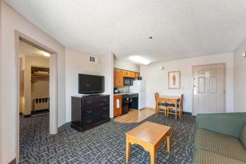 a living room with a couch and a tv and a table at Metro Scottsdale Apartments 1 bd in Scottsdale