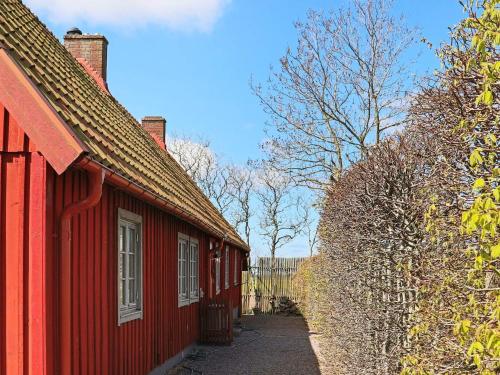 a row of red buildings with trees in the background at 6 person holiday home in BÅSTAD-By Traum in Båstad
