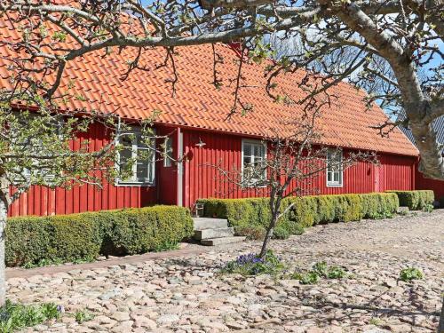 a red house with a tree in front of it at 6 person holiday home in BÅSTAD-By Traum in Båstad