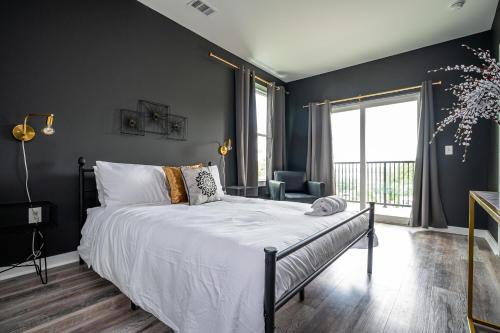 um quarto com uma cama e uma grande janela em Downtown New-Built Roof-top balcony City View 525Pkwy419 em Atlanta