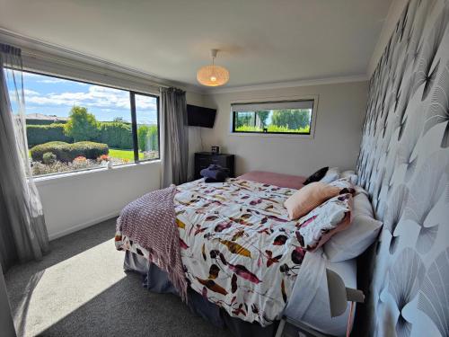 1 dormitorio con cama y ventana grande en Gorgeous in the Glen en Kennington