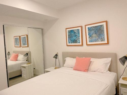a bedroom with two beds and a mirror at Cosy and Stylish 1 BD Serviced Apt at SouthBank in Brisbane