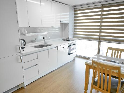 a white kitchen with a sink and a table at Residence Hotel K Okpo in Geoje 