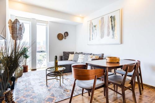 a living room with a table and chairs and a couch at Increíble departamento en Santa Fe con gym, alberca y estacionamiento in Mexico City