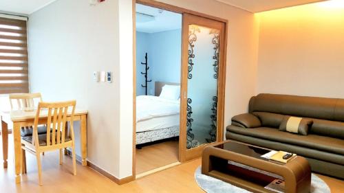 a living room with a couch and a mirror at Residence Hotel K Okpo in Geoje 
