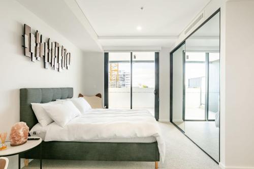 a bedroom with a green bed and a table at Modern 2BR Apartment near Wollongong Beach in Wollongong