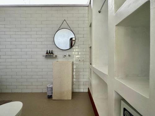 La salle de bains blanche est pourvue d'un miroir et d'un lavabo. dans l'établissement Mossca Mooi, à Ubud