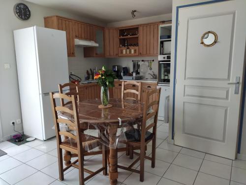 une cuisine avec une table, des chaises et un réfrigérateur dans l'établissement Maison ensoleillée proche plage de la Grière, 4 pers., terrasse, WiFi, parking privé - FR-1-194-239, à La Tranche-sur-Mer