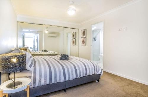 um quarto com uma cama e um espelho em Luxurious 3BDR Townhouse in Great Location em Brisbane