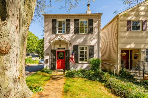a house with a red door and a flag at The Walton House - historic 3bd 2 5ba with parking in Kennett Square