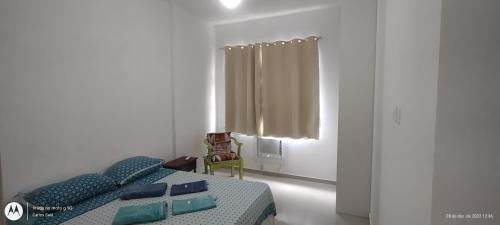 a bedroom with a bed and a chair and a window at Temporada Copacabana Salu in Rio de Janeiro
