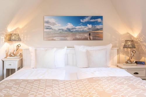 ein weißes Schlafzimmer mit einem Bett und zwei Lampen in der Unterkunft Tunghörn Hüs in Keitum