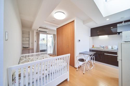 a kitchen and dining room with a crib in a room at Yuzuki Dome Osaka Kujo in Osaka
