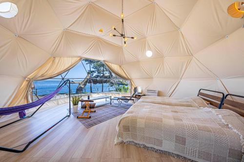 una camera da letto con una tenda con amaca di La-gom a Inatori