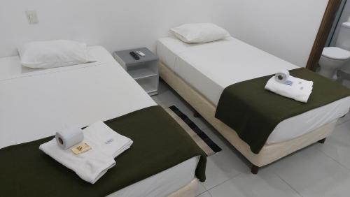 Dos camas en una habitación con toallas. en Casa de Mia en Asunción