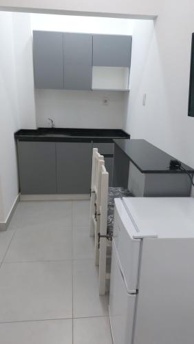 a kitchen with white cabinets and a black counter top at Casa de Mia in Asuncion