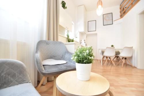 a living room with a chair and a table with a plant at Hidden Gem in Central Innsbruck with free Parking in Innsbruck