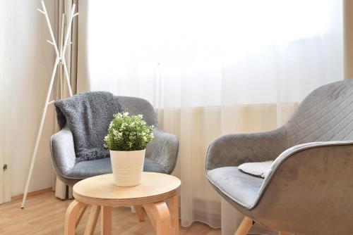 two chairs and a table with a vase of flowers at Hidden Gem in Central Innsbruck with free Parking in Innsbruck