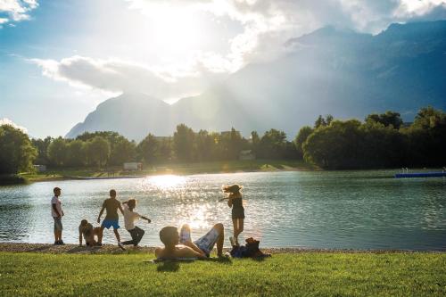 a group of people sitting on the shore of a lake at Hidden Gem in Central Innsbruck with free Parking in Innsbruck