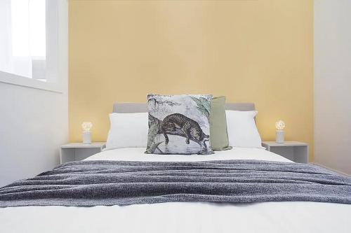 a bed with a grey blanket and a pillow on it at Comfortable 1Bed Unit Right Near Bondi Beach - FAST WIFI For Working At Home in Sydney