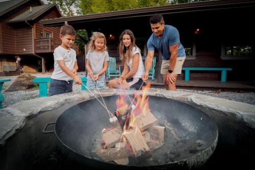 a group of people standing around a fire pit at Rustic Modern Getaway - Mtn View - Creek - Hammock - Rest in Sevierville