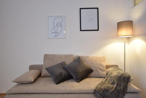 a couch with pillows on it in a living room at Super central city appartement with free parking in Innsbruck