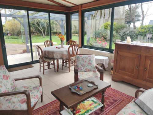 un salon avec une table et des chaises dans l'établissement Maison 6 pers, 600m plage, jardin, barbecue, parking - FR-1-639-92, à Sarzeau