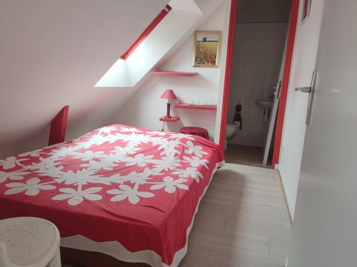 ein Schlafzimmer mit einem roten und weißen Bett in einem Zimmer in der Unterkunft Maison 6 pers, 600m plage, jardin, barbecue, parking - FR-1-639-92 in Sarzeau