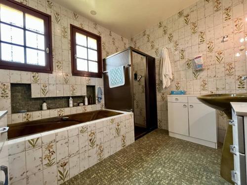 une salle de bain avec une baignoire et un lavabo dans l'établissement Grande maison à 2 pas de la plage, 3 ch, jardin, BBQ, parking – Saint-Pierre-d'Oléron - FR-1-246A-233, à Saint-Pierre-dʼOléron