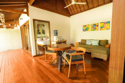 a living room with a table and a couch at Pera ONE Villas in Gili Trawangan