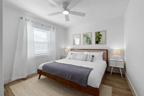 a white bedroom with a bed and a ceiling fan at Duneside Bliss - Steps to the Ocean & Mins to DT in St. Augustine