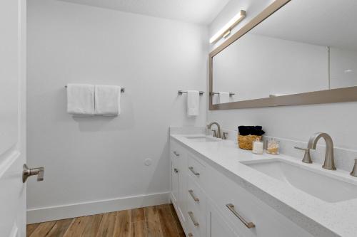 a white bathroom with two sinks and a mirror at Duneside Bliss - Steps to the Ocean & Mins to DT in Saint Augustine