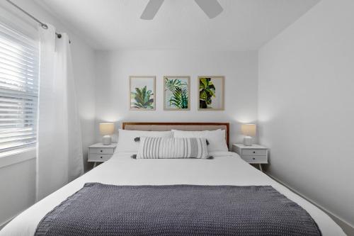 a white bedroom with a large bed with two night stands at Duneside Bliss - Steps to the Ocean & Mins to DT in Saint Augustine
